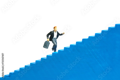Miniature people toy figure photography. A boy pupil student running on staircase. Isolated on a white background
