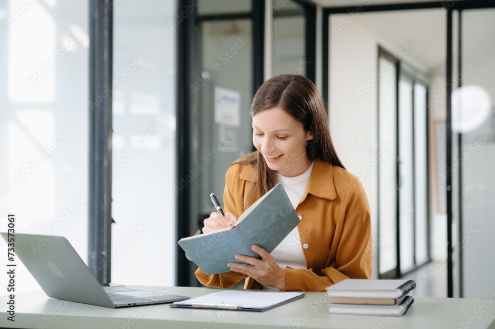 Confident woman with a smile standing holding notepad and tablet at the office. Confident woman with a smile standing holding notepad and tablet at the office.