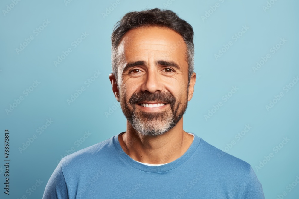 Portrait of a happy middle-aged man smiling at the camera on a blue background Portrait of a happy middle-aged man smiling at the camera on a blue background