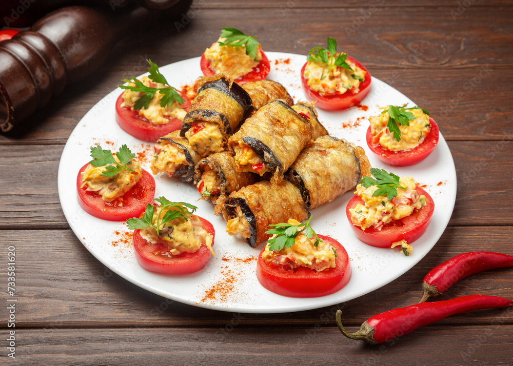 Appetizer: stuffed eggplants and tomatoes. On a wooden background. Appetizer: stuffed eggplants and tomatoes. On a wooden background.