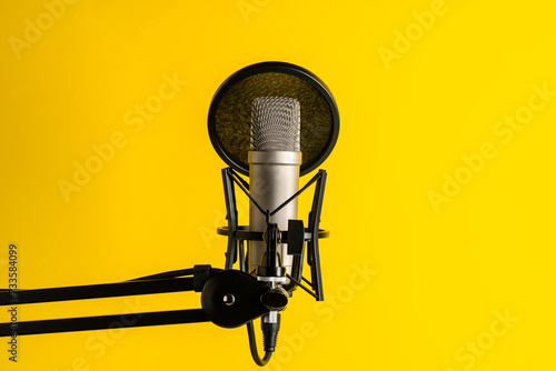 Professional microphone stand over yellow studio background