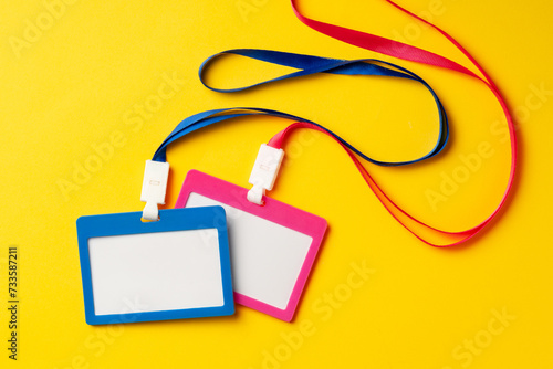 Colored blank nametags on strings on yellow background