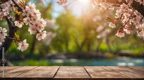 A serene spring scene unfolds before you  with an empty wooden table beckoning you to create your own masterpiece. The natural template of cherry blossoms and bokeh adds a touch of whimsy