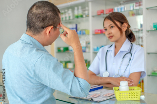 Young asian pharmacist receive credit card payment pharmacy on the customer's settle medical expenses