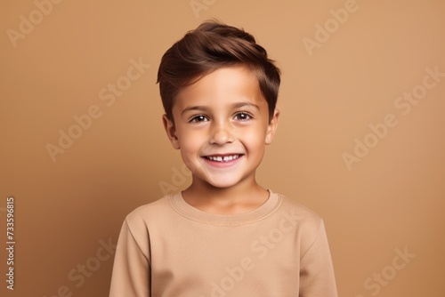 Portrait of a cute little boy on a brown background, smiling