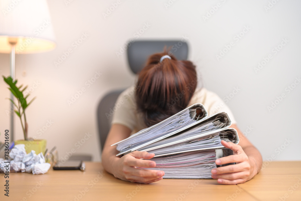 Stressed Asian woman having Tired and Sleepy while working, female businesswoman having headache at office, Exhausted woman with documents folder stack at home late night. Overworked and Overtime Stressed Asian woman having Tired and Sleepy while working, female businesswoman having headache at office, Exhausted woman with documents folder stack at home late night. Overworked and Overtime