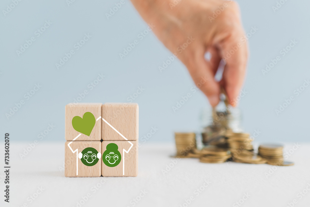 Obraz premium Planning money saving for retirement, investment for expense after retire life. Pension insurance, life insurance concept. Old persons inside house on wooden blocks and blurred hand arranged coins