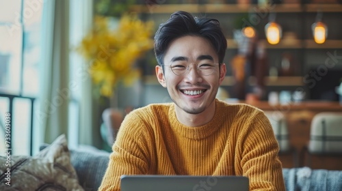Asian man is smiling and expressing happy feeling on the computer laptop screen. young male got good news and show his cheerful face.Happiness men looking on laptop read message feel excited at home photo