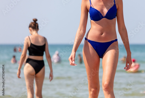 Girl in a blue swimsuit on the sea beach