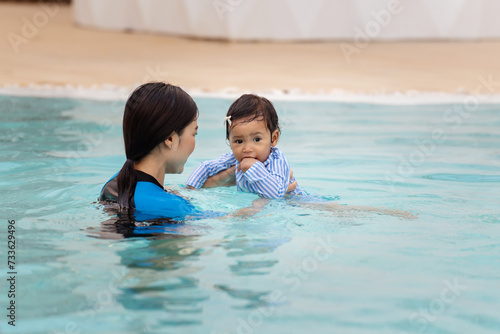 mother teaching her daughter swimming in pool © geargodz