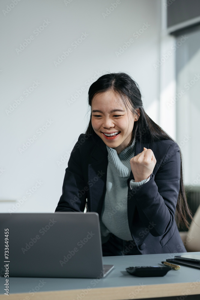Asian business woman are excited business success with inspiration from their excellent financial results that are happy working in a modern office on a computer.