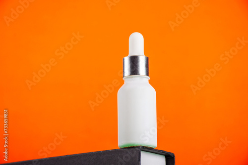 Plastic white tube for cream or lotion. Skin care or sunscreen cosmetic with stylish props on orange background 