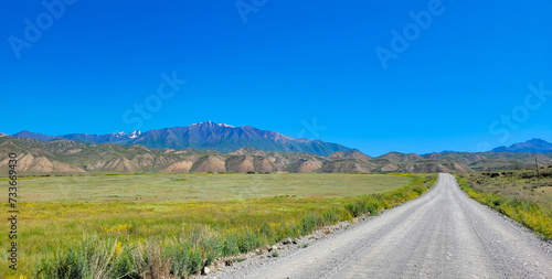 Mountain road along a beautiful plateau between mountain ranges. An untrodden path full of adventures and beautiful views. photo