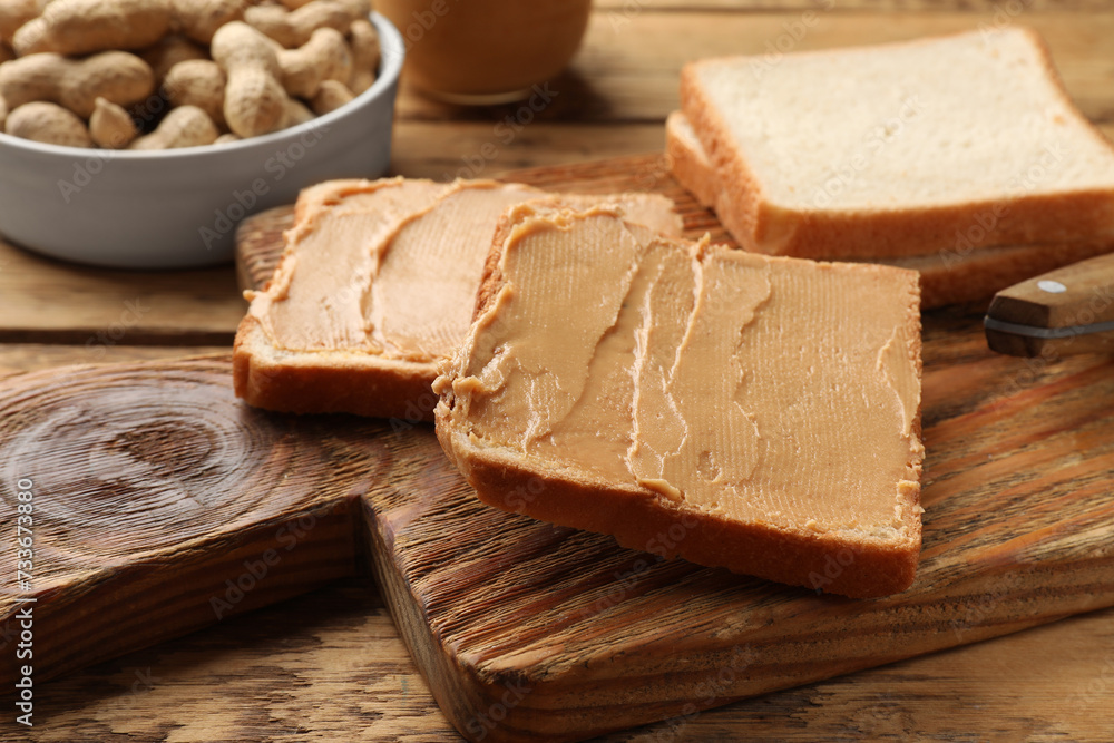 Tasty peanut butter sandwiches on wooden table, closeup view
