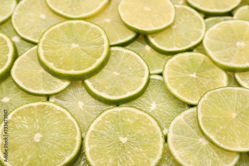 Many juicy lime slices as background, above view