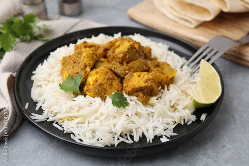 Delicious chicken curry with rice on grey table, closeup