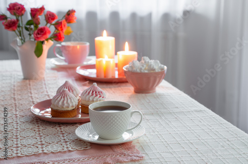 cup of coffee with dessert and roses on table
