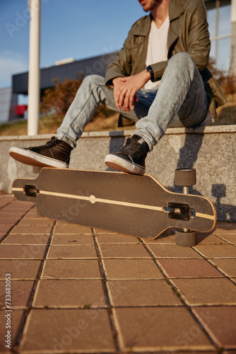 Cropped shot of relaxed hipster skateboarder with focus on foot placed on board
