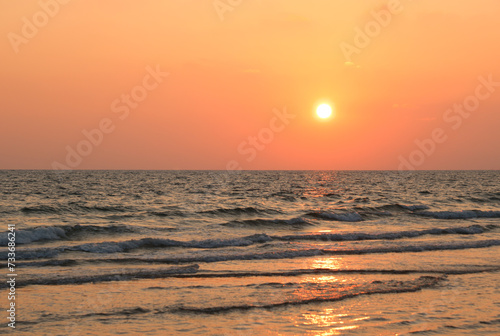 Sunset over the water with beautiful orange and red twilight glow, reflections in the water. Setting sun. Epic seascape, Landscape © natthapol
