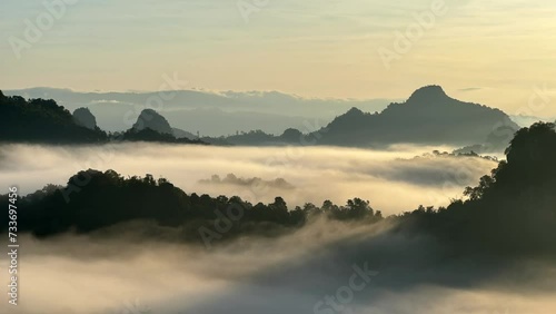 4K video Timelapse of Sunrise painted gold over misty mountain peaks. photo