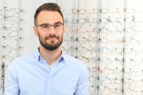 Man choosing glasses in eyewear store