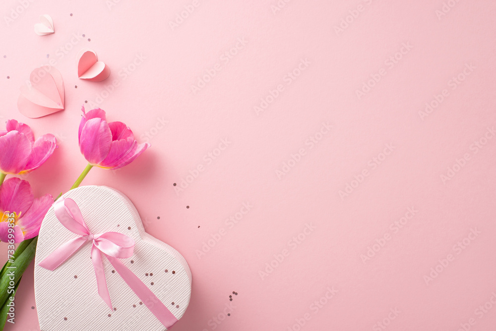 Quintessential girly party layout. Top view of a heart-shaped box with a ribbon, sparkles, love hearts, and a fresh bunch of tulips on a pastel pink backdrop, with space for copy Quintessential girly party layout. Top view of a heart-shaped box with a ribbon, sparkles, love hearts, and a fresh bunch of tulips on a pastel pink backdrop, with space for copy