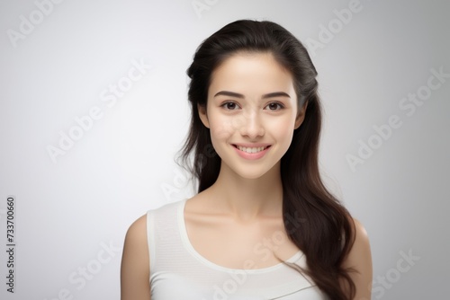 Sweet young girl dressed in comfortable vest undergarments  exuding confidence as she poses gracefully on a pristine white surface. Generative AI.