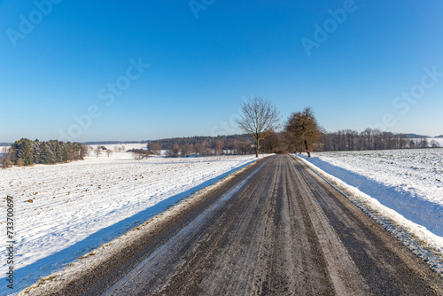 Snowy and frozen road in winter landscape.