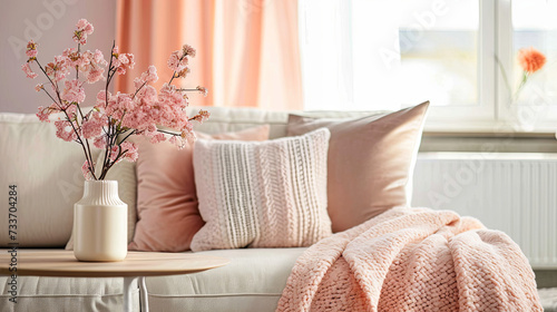 Peach fluff colored pillows lie on a sofa 