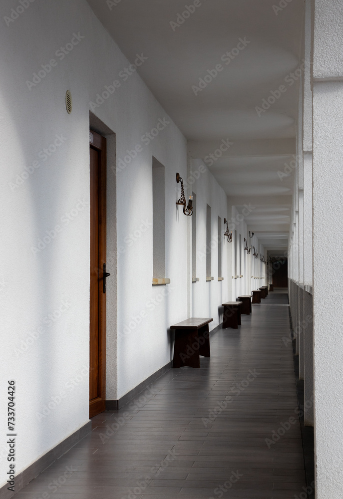 A long straight corridor with white walls