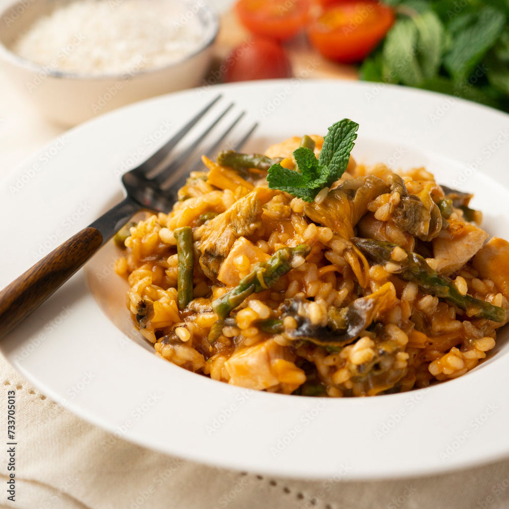 Traditional Spanish rice paella with chicken and autumn mushrooms. Delicious tapa of Spanish gastronomy.