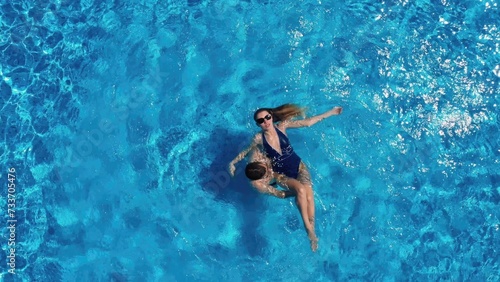 View from above. The couple have fun in the pool. A young attractive couple is relaxing in the pool. Enjoying each other s company.