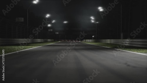 Two modern race cars racing on a speedway at night photo