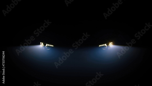 Car headlights flashing in the dark. Headlights of a sports car with an indicator in a dark background. The concept of new car technologies and car showrooms.