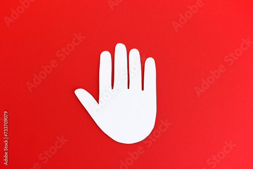 Stop Hand - No means no - Paper cutout of white stop gesture in shape of hand on bright red background