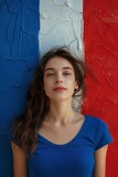 a brunette in blue t-shirt is posing in front of a French flag painted on a wall. Summer Olympics 2024 in Paris. Generative AI