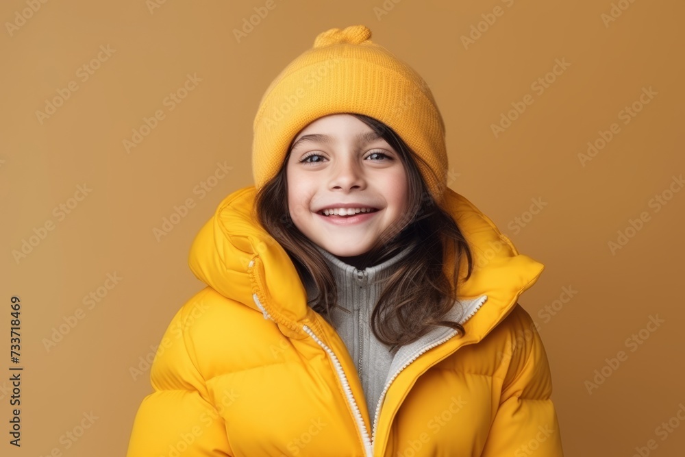 Little girl in a yellow jacket and a hat on a yellow background Little girl in a yellow jacket and a hat on a yellow background
