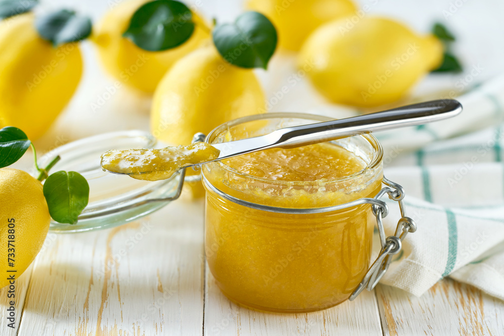 Homemade lemon marmalade and fresh lemons and green leafs on the kitchen table. Homemade lemon marmalade and fresh lemons and green leafs on the kitchen table.
