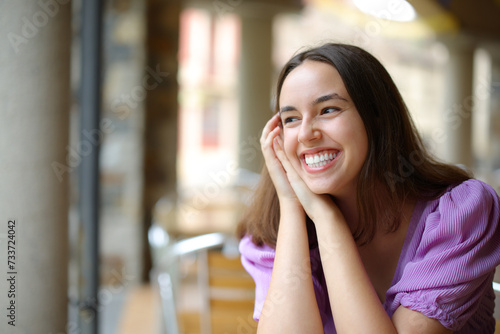 Happy woman laughing alone in a bar