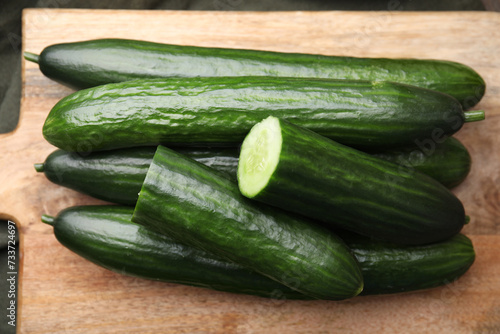 Fresh cucumbers on wooden board, above view