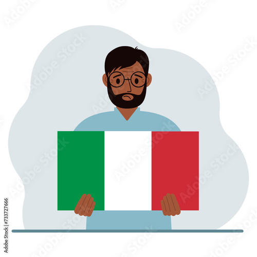 A man holds an Italian flag in his hands. The concept of demonstration, national holiday or patriotism.