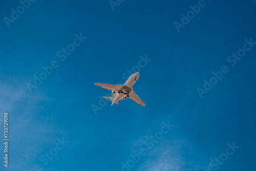 Italy, Milan, San Donato Milanese 14.12.2023. Low flying plane landing at the airport Linate. Airplane against blue sky.