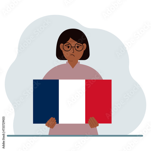 A woman holds a French flag in his hands. The concept of demonstration, national holiday or patriotism. Nationality.