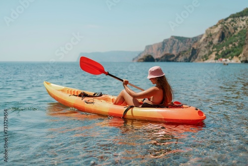 Kayak sea woman. Happy attractive woman with long hair in red swimsuit, swimming on kayak. Summer holiday vacation and travel concept. © svetograph