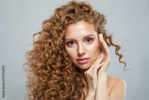Stylish healthy model with natural make-up, shiny clear skin and long curly hairstyle. Haircare, Skincare, Cosmetology and Styling concept