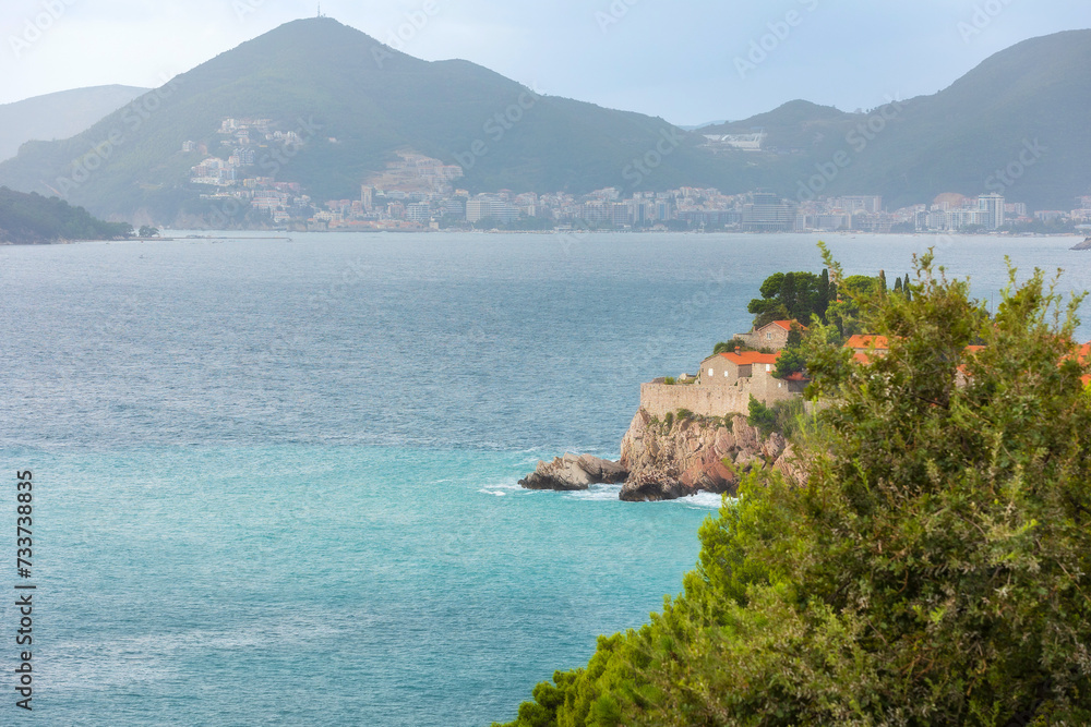 Sveti Stefan island in Montenegro resort at Adriatic sea and Budva skyline. High angle view. Famous travel destination