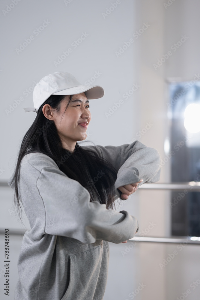 Pretty young woman in hoodie and cap enjoy practicing break dance at studio Pretty young woman in hoodie and cap enjoy practicing break dance at studio