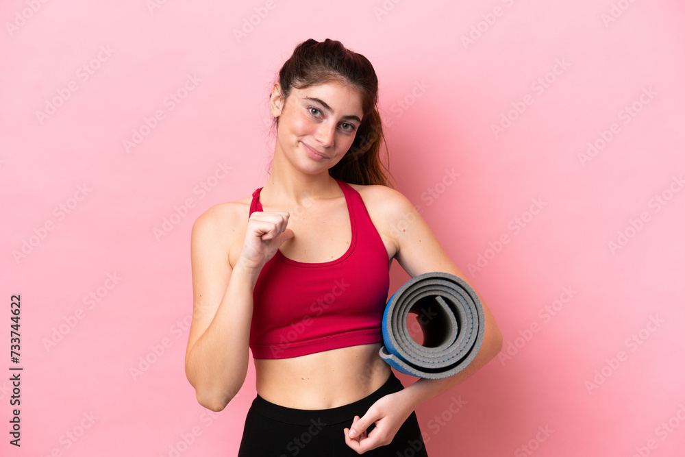 Young sport woman going to yoga classes while holding a mat proud and self-satisfied Young sport woman going to yoga classes while holding a mat proud and self-satisfied