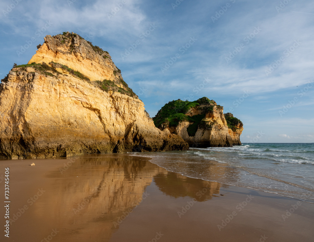 Sea stacks and rock formations on the pristine sand of Praia dos Três Irmãos (three brothers) beach, Alvor, Algarve, Portugal