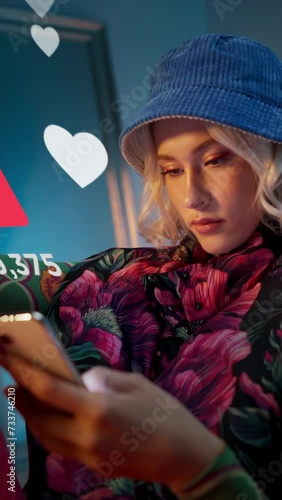 Blonde young trendy woman using her phone to interact with social media, getting followers, likes, emoji feedback